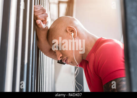 Schön müde Mann lehnte sich an der Wand Stockfoto