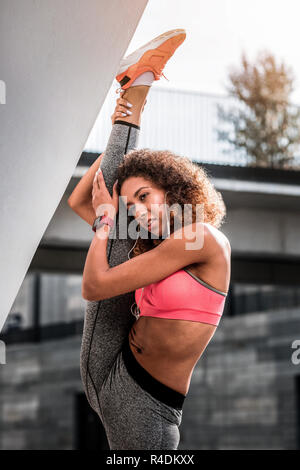 Ernsthafte schöne Frau eine ausdehnende Übung Stockfoto