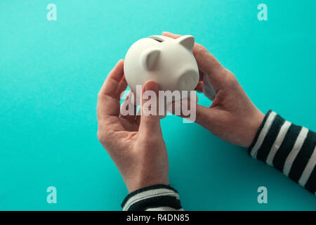 Weibliche Hände und piggy coin Bank für Geld zu sparen, Konzept Stockfoto