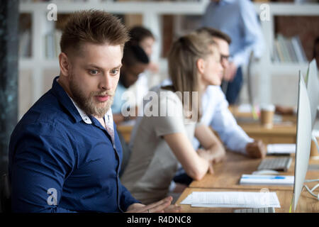 Schockiert Geschäftsmann durch Lesen unglaubliche Nachrichten überrascht Stockfoto