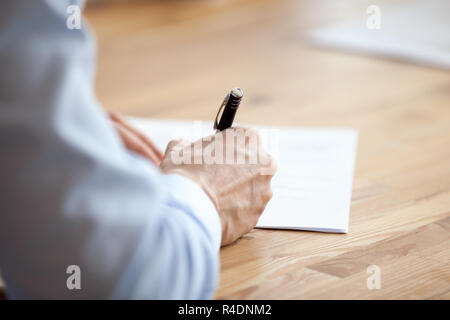 Mann Hand mit Stift, Verfassen von Notizen in der Sitzung schließen Stockfoto