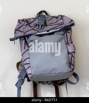 Lila Schule Rucksack an der Wand hängen - isoliertes Objekt mit weißem Hintergrund Stockfoto