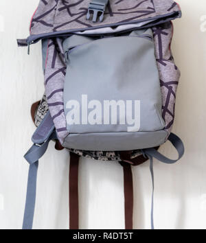 Lila Schule Rucksack an der Wand hängen - isoliertes Objekt mit weißem Hintergrund Stockfoto