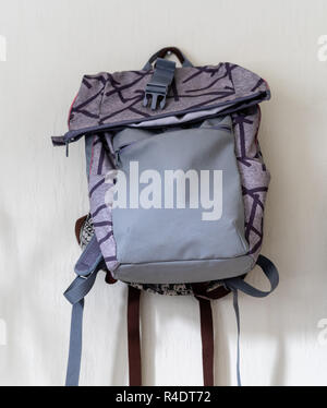 Lila Schule Rucksack an der Wand hängen - isoliertes Objekt mit weißem Hintergrund Stockfoto