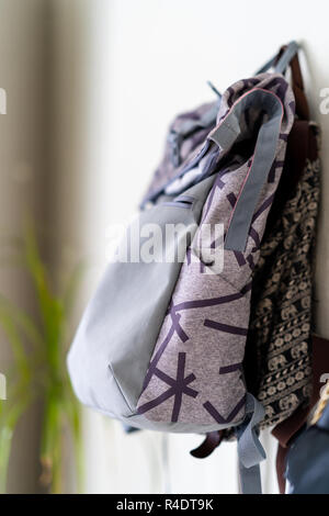 Lila Schule Rucksack an der Wand hängen - isoliertes Objekt mit weißem Hintergrund Stockfoto