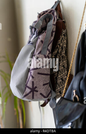 Lila Schule Rucksack an der Wand hängen - isoliertes Objekt mit weißem Hintergrund Stockfoto