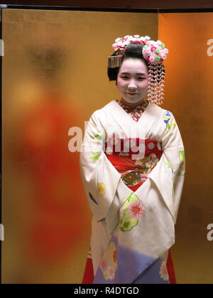 Eine 16 Jahre alte Maiko (Azubi Geisha) in voller Tracht, in der Gastfreundschaft und Unterhaltung Industrie in modernen Kyoto, Japan arbeiten Stockfoto