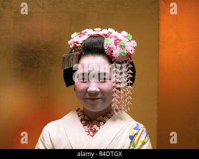 Eine 16 Jahre alte Maiko (Azubi Geisha) in voller Tracht, in der Gastfreundschaft und Unterhaltung Industrie in modernen Kyoto, Japan arbeiten Stockfoto