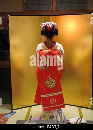 Rückansicht eines 16 Jahre alten Maiko (Azubi Geisha) in voller Tracht, die in der Hotellerie und in modernen Kyoto, Japan Stockfoto