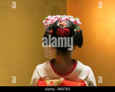 Rückansicht eines 16 Jahre alten Maiko (Azubi Geisha) in voller Tracht, die in der Hotellerie und in modernen Kyoto, Japan Stockfoto