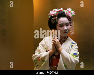 Eine 16 Jahre alte Maiko (Azubi Geisha) in voller Tracht, in der Gastfreundschaft und Unterhaltung Industrie in modernen Kyoto, Japan arbeiten Stockfoto