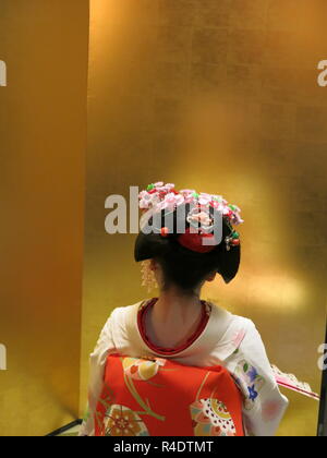 Rückansicht eines 16 Jahre alten Maiko (Azubi Geisha) in voller Tracht, die in der Hotellerie und in modernen Kyoto, Japan Stockfoto