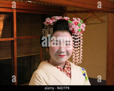 Eine 16 Jahre alte Maiko (Azubi Geisha) in voller Tracht, in der Gastfreundschaft und Unterhaltung Industrie in modernen Kyoto, Japan arbeiten Stockfoto