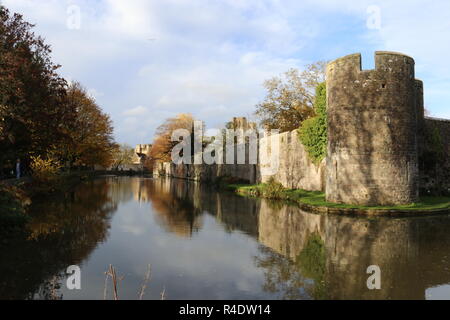 Die äußeren Wände und Graben der Bischöfe Palast und die Gärten in den Brunnen. Herbst Szene mit einer Außenwand eines Palastes. Wells, Somerset, England, UK. Stockfoto