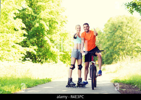 paar auf Rollerblades und Fahrrad Daumen auftauchen Stockfoto