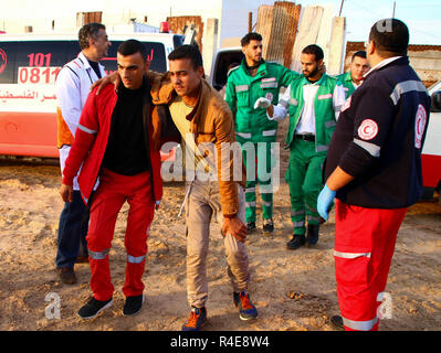 Gaza, Palästina. 26. Nov 2018. Palästinensische Mediziner mit einem verletzten Mann während der Auseinandersetzungen zwischen Palästinensern und der israelischen Besatzungstruppen im nördlichen Gazastreifen in der Nähe der Basis der Zakim aus Protest gegen die Anerkennung von Jerusalem als Hauptstadt von Israel durch US-Präsident Trump gesehen und abgelehnt, den Gazastreifen zu blockieren. Credit: SOPA Images Limited/Alamy leben Nachrichten Stockfoto