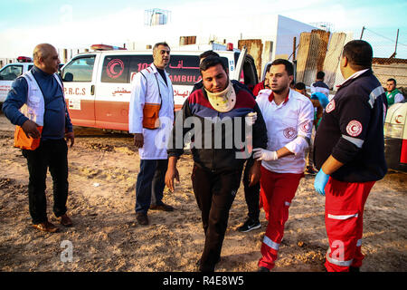 Gaza, Palästina. 26. Nov 2018. Palästinensische Mediziner mit einem verletzten Mann während der Auseinandersetzungen zwischen Palästinensern und der israelischen Besatzungstruppen im nördlichen Gazastreifen in der Nähe der Basis der Zakim aus Protest gegen die Anerkennung von Jerusalem als Hauptstadt von Israel durch US-Präsident Trump gesehen und abgelehnt, den Gazastreifen zu blockieren. Credit: SOPA Images Limited/Alamy leben Nachrichten Stockfoto