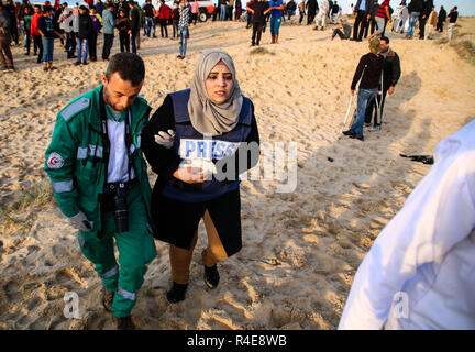 Gaza, Palästina. 26. Nov 2018. Mitglied des Medical Team mit dem Journalisten Safinaz al-Louh, die während der Auseinandersetzungen zwischen Palästinensern und der israelischen Besatzungstruppen im nördlichen Gazastreifen in der Nähe der Basis der Zakim aus Protest gegen die Anerkennung von Jerusalem als Hauptstadt von Israel durch US-Präsident Trump verletzt wurde und sich weigerte, den Gazastreifen zu blockieren. Credit: SOPA Images Limited/Alamy leben Nachrichten Stockfoto