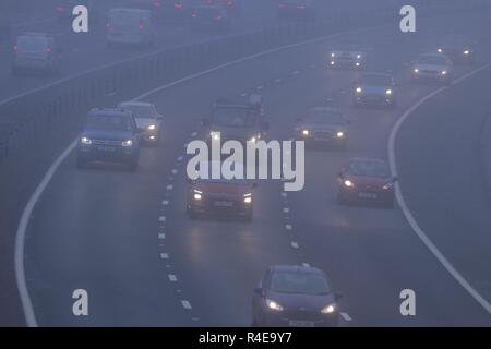 Leeds, West Yorkshire, UK. 27. November 2018. Die Verkehrsteilnehmer strebe, wie Sie durch dichten Nebel während der Rush Hour auf der Autobahn M1 in Leeds Schlacht. Credit: Yorkshire Pics/Alamy Live News Credit: Yorkshire Pics/Alamy leben Nachrichten Stockfoto