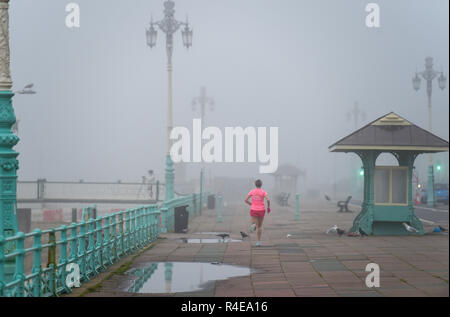 Brighton, UK. 27 Nov, 2018. Ein Läufer in dichtem Nebel auf Brighton Seafront heute Morgen, aber milder und feuchter Witterung ist für Großbritannien im Laufe der nächsten Tage Kredit Prognose: Simon Dack/Alamy leben Nachrichten Stockfoto