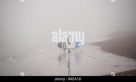 Brighton, UK. 27 Nov, 2018. Ein Paddel boarder entsteht aus dichtem Nebel auf Brighton Beach von der West Pier in Brighton, heute Morgen, aber milder und feuchter Witterung ist für Großbritannien im Laufe der nächsten Tage Kredit Prognose: Simon Dack/Alamy leben Nachrichten Stockfoto