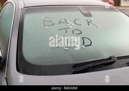 Glasgow, Schottland, Großbritannien. 27. Nov 2018. UK Wetter: minus Temperaturen über Nacht ein Auto Besitzer die Worte "zurück zu Bett zu schreiben' in der Frost auf seine/ihre autoscheibe sie dazu aufgefordert werden. Stockfoto