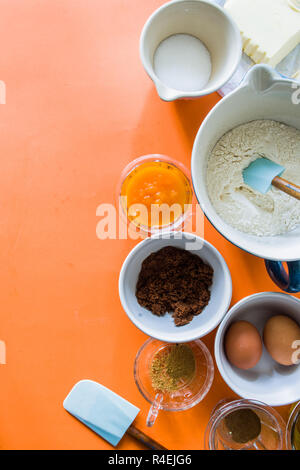 Zutaten einige muffin Kürbis für Halloween vorbereitet sind auf einer Blu rustikalen Board angezeigt, flach Draufsicht, natürliche Beleuchtung. Stockfoto