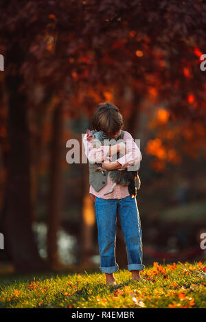 Junge draußen Kuscheln ein Huhn, United States Stockfoto