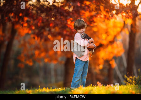 Junge draußen Kuscheln ein Huhn, United States Stockfoto