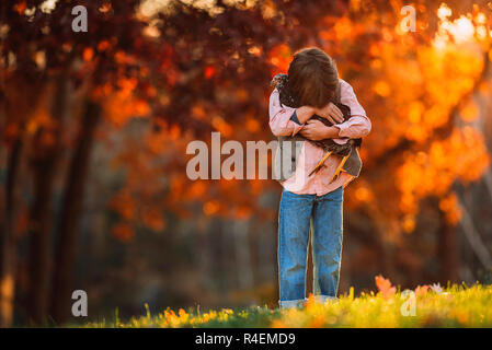 Junge draußen Kuscheln ein Huhn, United States Stockfoto