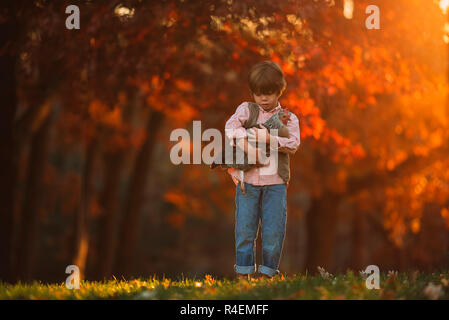 Junge draußen Kuscheln ein Huhn, United States Stockfoto