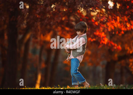 Junge draußen Kuscheln ein Huhn, United States Stockfoto