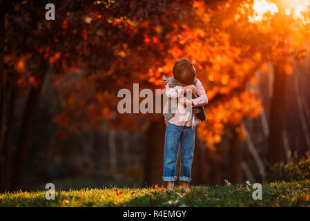 Junge draußen Kuscheln ein Huhn, United States Stockfoto