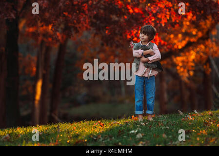 Junge draußen Kuscheln ein Huhn, United States Stockfoto