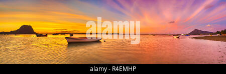 Fischerboot bei Sonnenuntergang. Le Morn Brabant für den Hintergrund. Panorama Stockfoto