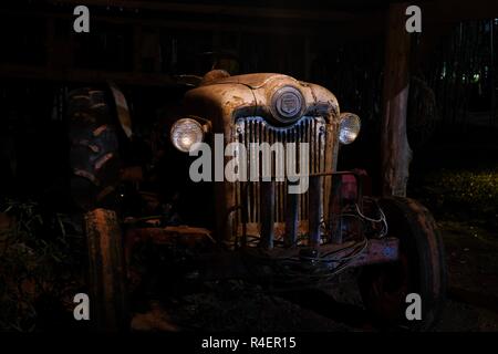 LAFAYETTE, Alabama - November 22, 2018: Funktionsprüfung 1953 Ford Jubiläums Oldtimer Traktor in einem alten schwach beleuchteten Scheune in der Nacht.