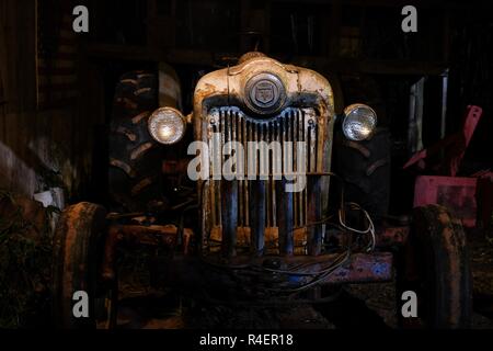 LAFAYETTE, Alabama - November 22, 2018: Funktionsprüfung 1953 Ford Jubiläums Oldtimer Traktor in einem alten schwach beleuchteten Scheune. Winkel gibt dem Traktor einen bösen oder Stockfoto