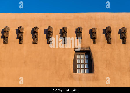 Pueblo Stil adobe Gebäudewand und rustikalem Holz gerahmte Fenster und Strahl endet in Santa Fe, New Mexico Stockfoto