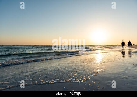 Sarasota, USA Sonnenuntergang in Siesta Key, Florida mit Küste Küste Ozean Golf von Mexiko am Strand Land, Silhouette zu Fuß durch Wellen Stockfoto