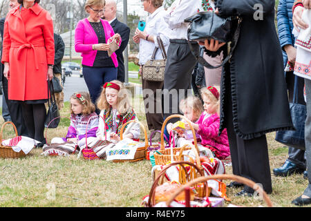 Washington DC, USA - April 1, 2018: Kinder, Leute sitzen auf dem Boden in der traditionellen Kleidung draussen, im Freien, Ostern Körbe für Segen an Ukrain Stockfoto