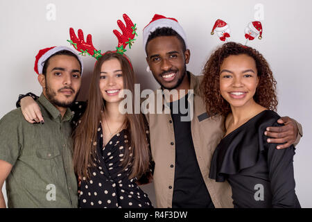 Gruppe von Freunden in lustige Weihnachten Stirnbänder und Hüte auf einem weißen Hintergrund. Stockfoto