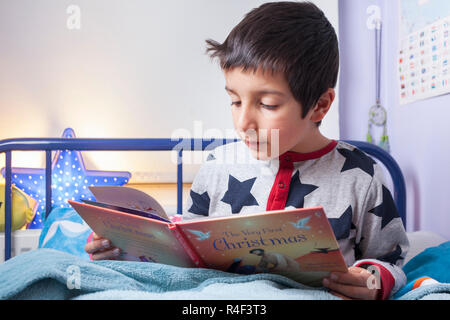 UK, Junge ,6 Jahre alt liest im Bett Stockfoto