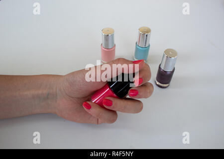 Frau Hände halten pink-nagellack Flasche Stockfoto