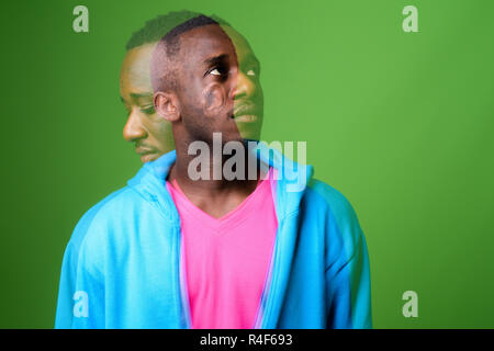 Doppelt belichtete Aufnahme der jungen afrikanischen Mann gegen grüner Hintergrund Stockfoto