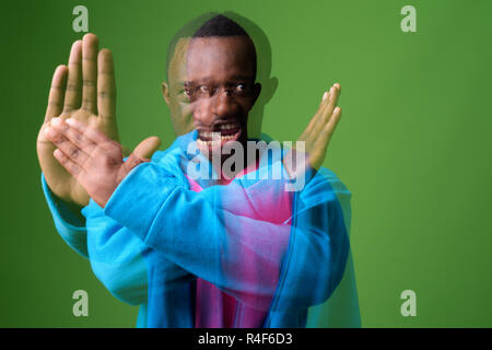 Doppelt belichtete Aufnahme der jungen afrikanischen Mann gegen grüner Hintergrund Stockfoto