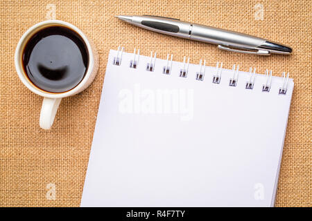 Leere Spirale Art Skizzenbuch gegen gegen Leinwand Leinwand mit einer Tasse Kaffee Stockfoto