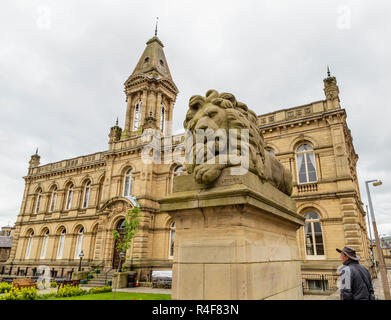 Eine der Saltaire Lions außerhalb Victoria Hall, Saltaire, Yorkshire. Es gibt vier Löwen Skulpturen, dieser steht für Frieden. Stockfoto