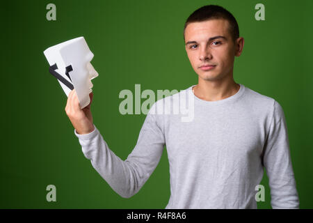 Studio shot Junger stattlicher Mann gegen grüner Hintergrund Stockfoto