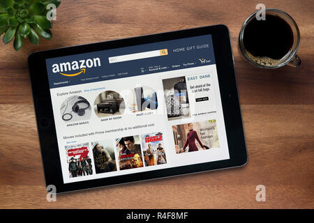 Die Website von Amazon ist auf einem iPad Tablet gesehen, auf einer hölzernen Tisch zusammen mit einem Espresso und einem Haus Anlage (nur redaktionelle Nutzung). Stockfoto