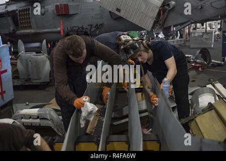 ARABIAN GULF (Okt. 2010) 25, 2016) Segler sauber MH-60R Sea Hawk Hubschrauber Rotorblätter im Hangar Bucht der Flugzeugträger USS Dwight D. Eisenhower (CVN 69) (IKE). Ike und Ihre Carrier Strike Group sind zur Unterstützung der Operation inhärenten Lösen, Maritime Security Operations und Theater Sicherheit Zusammenarbeit in den USA 5 Flotte Bereich der Operationen eingesetzt. Stockfoto